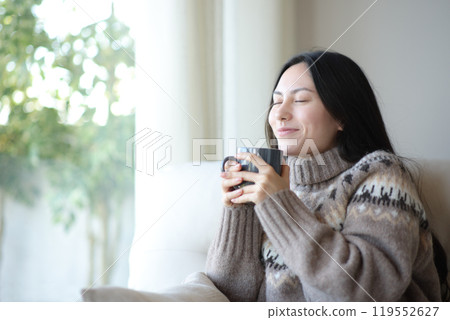 Asian woman in winter relaxing drinking coffee at home 119552627