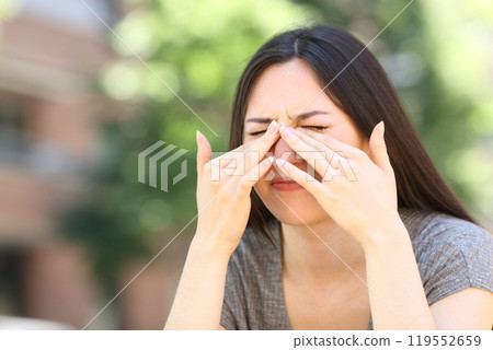Asian woman scratching itchy eyes in the street Asian woman scratching itchy eyes in the street 119552659