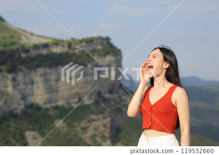 Asian woman screaming in the mountain on vacation Asian woman screaming in the mountain on vacation 119552660