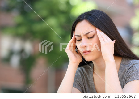 Asian woman suffering migraine attack in the street 119552668