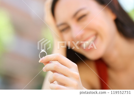 Happy asian woman looking at engagement ring Happy asian woman looking at engagement ring 119552731