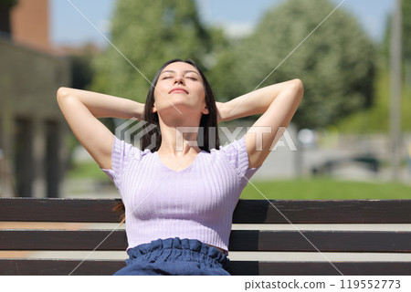 Mixed race woman relaxing in a bench in a park Mixed race woman relaxing in a bench in a park 119552773