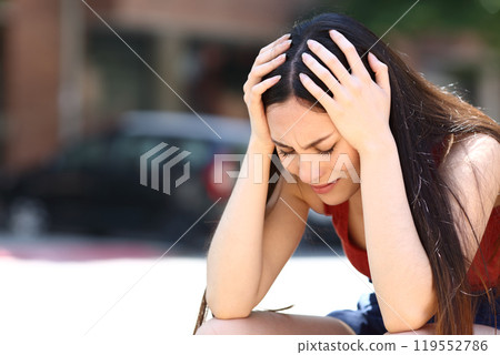 Sad asian woman complaining alone in the street Sad asian woman complaining alone in the street 119552786