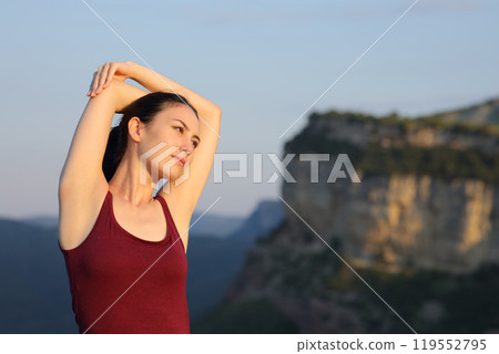 Serious asian woman stretching arms in nature 119552795