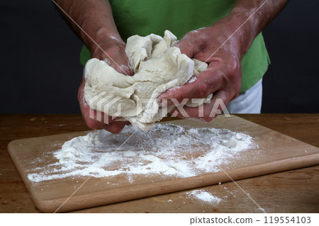 Baker preparing some dough ready to bake some bread Baker preparing some dough ready to bake some bread 119554103