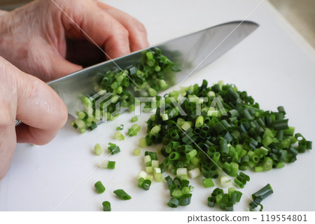 Senior woman's hands cutting green onions Senior woman's hands cutting green onions 119554801