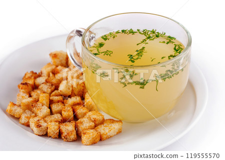 Glass cup of chicken broth with croutons on white background 119555570