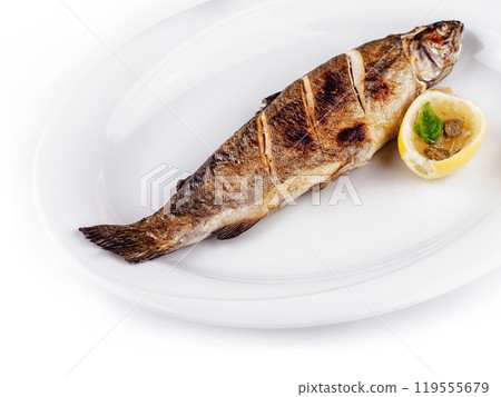 Grilled trout lying on white plate with lemon and capers Grilled trout lying on white plate with lemon and capers 119555679