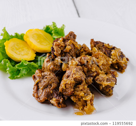 Delicious beef stew with potatoes and onions lying on white plate on white background Delicious beef stew with potatoes and onions lying on white plate on white background 119555692
