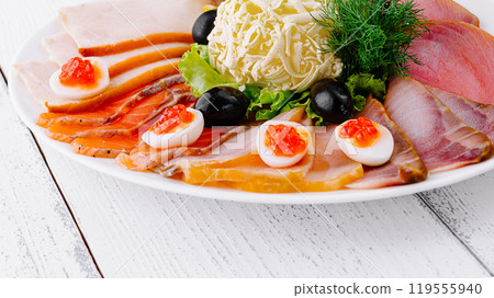 Delicious sliced fish platter with butter lemon and olives on white table Delicious sliced fish platter with butter lemon and olives on white table 119555940