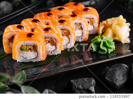 Philadelphia sushi roll being served on black plate with wasabi and ginger Philadelphia sushi roll being served on black plate with wasabi and ginger 119555997