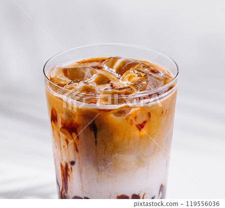 Iced coffee latte with milk and chocolate syrup drizzled on glass Iced coffee latte with milk and chocolate syrup drizzled on glass 119556036