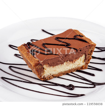 Chocolate tartlet decorated with chocolate sauce on white plate 119556038