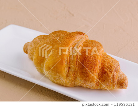 Fresh golden croissant on white plate Fresh golden croissant on white plate 119556151
