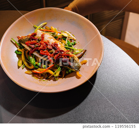 Grilled sea bass fillet with sauteed vegetables on restaurant table Grilled sea bass fillet with sauteed vegetables on restaurant table 119556155