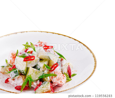Fresh salad with cucumber and tomato seasoned with red chili pepper on white plate 119556283