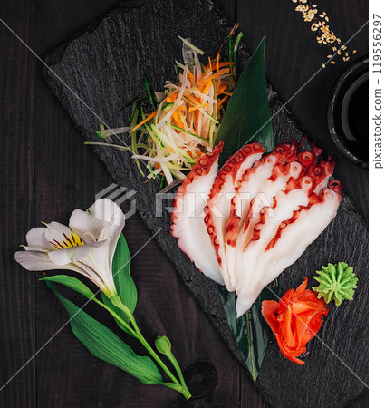 Sliced octopus sashimi with wasabi and ginger on slate serving board Sliced octopus sashimi with wasabi and ginger on slate serving board 119556297