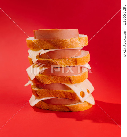 Tall sandwich tower balancing on red background 119556299