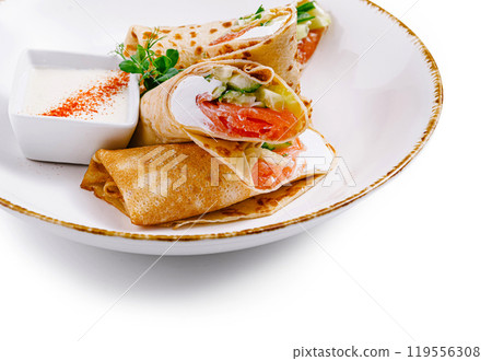 Pancakes with salmon and cream cheese filling on white plate Pancakes with salmon and cream cheese filling on white plate 119556308