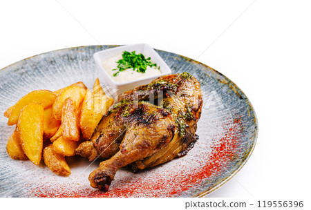 Roasted chicken with golden potatoes and white sauce on a plate Roasted chicken with golden potatoes and white sauce on a plate 119556396