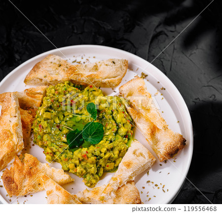 Avocado chickpea salad with pita triangles 119556468
