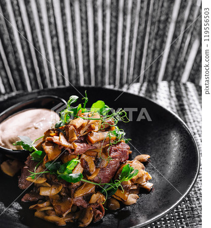 Gourmet fried mushrooms with beef steak and dip on elegant plate 119556503