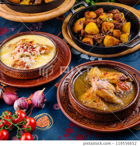 Traditional georgian food served in clay pots standing on a decorated table Traditional georgian food served in clay pots standing on a decorated table 119556652