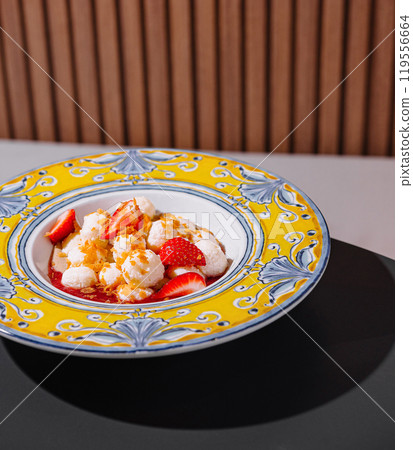 Delicious dessert with strawberries and cream being served on decorated plate 119556664