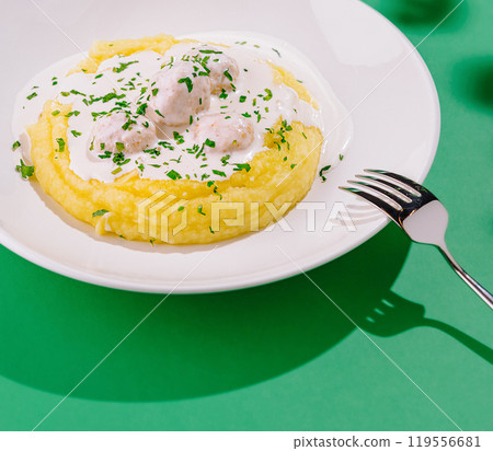 Creamy chicken meatballs served on bed of mashed potatoes garnished with parsley Creamy chicken meatballs served on bed of mashed potatoes garnished with parsley 119556681