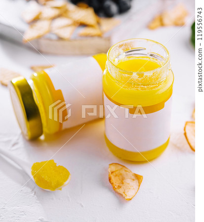 Two jars of ghee with blank labels and a spoonful on white background Two jars of ghee with blank labels and a spoonful on white background 119556743