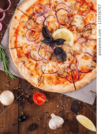 Delicious tuna pizza lying on wooden table surrounded by fresh ingredients 119556767