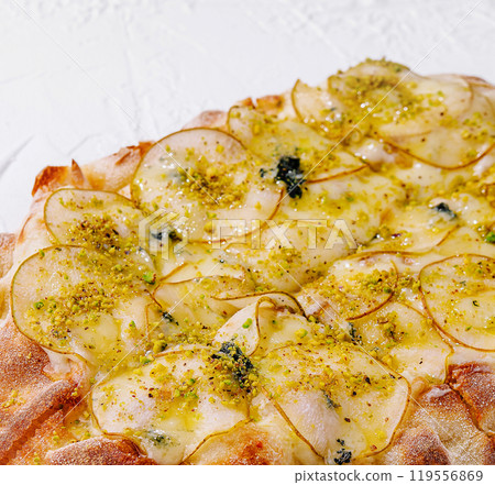 Delicious gourmet pizza with pears, pistachios and blue cheese being baked 119556869
