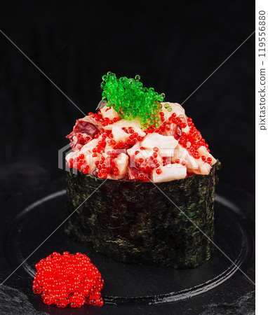 Gunkan maki sushi with tobiko red and green caviar standing on black stone plate 119556880