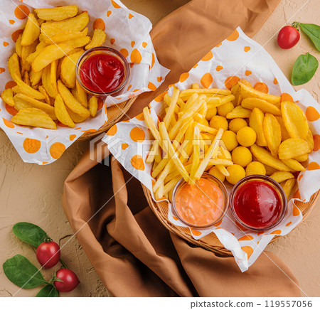 Assorted fried snacks with dipping sauces on table 119557056