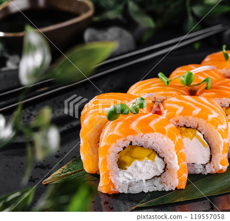 Salmon sushi roll platter on elegant dark background 119557058