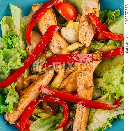 Chicken salad with peppers and lettuce on blue plate 119557258