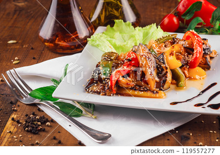 Delicious grilled eggplant, pepper and sesame seed dish on a white plate Delicious grilled eggplant, pepper and sesame seed dish on a white plate 119557277