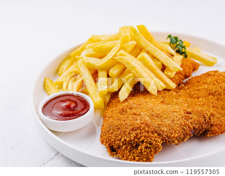 Breaded chicken breast schnitzel with french fries and ketchup on white plate Breaded chicken breast schnitzel with french fries and ketchup on white plate 119557305