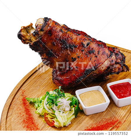 Roasted pork knuckle served on wooden board with sauces and salad 119557352