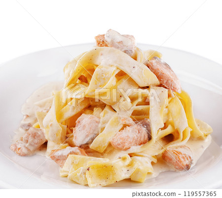 Delicious pasta dish with salmon and creamy sauce on white plate 119557365