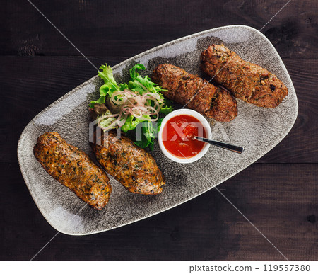 Traditional lula kebab on a plate with tomato sauce and salad 119557380