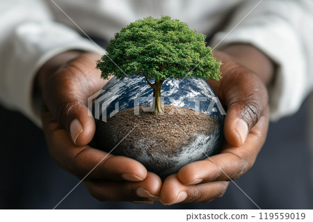A person is holding a globe with a tree on it. The globe is green and the tree is also green. The person is holding the globe with both hands and it is a gift A person is holding a globe with a tree on it. The globe is green and the tree is also green. The person is holding the globe with both hands and it is a gift 119559019