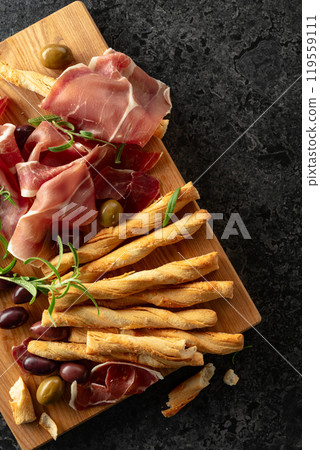 Italian prosciutto with bread sticks, olives, and rosemary. 119559111