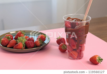 Whole fresh strawberries covered with melted liquid chocolate in cup. Sweet food, dessert on pink background. Whole fresh strawberries covered with melted liquid chocolate in cup. Sweet food, dessert on pink background. 119560127