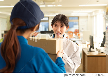 A female engineer in work clothes receiving a parcel A female engineer in work clothes receiving a parcel 119560762