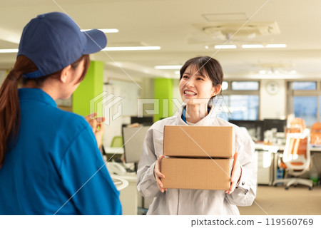 一位穿著工作服的女工程師從快遞員收到包裹 一位穿著工作服的女工程師從快遞員收到包裹 119560769