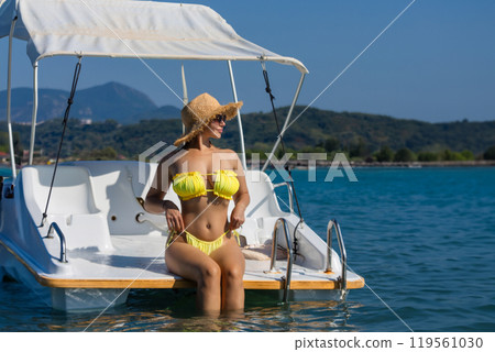 Young lady relaxing on the deck of the sail boat in the tropical sea at sunny day Young lady relaxing on the deck of the sail boat in the tropical sea at sunny day 119561030