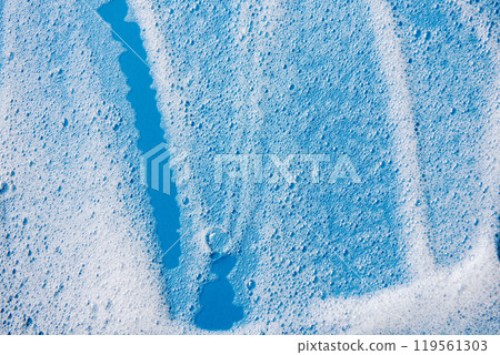 Background and pattern. White soap foam with bubbles, texture on blue tile background. 119561303
