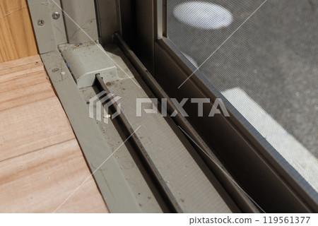 Dirt has accumulated in the gaps between the sliding window rails. 119561377