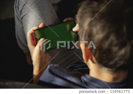 Child looking at phone screen. focus on phone. view from back 119561773